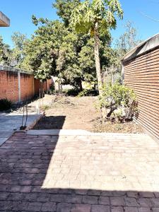 a brick driveway with a tree and a building at Casa Huerta in Ciudad Fernández