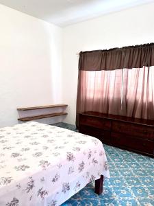 a bedroom with a bed and a dresser at Casa Huerta in Ciudad Fernández