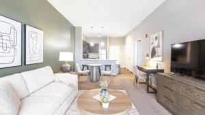 a living room with a white couch and a table at Landing Modern Apartment with Amazing Amenities (ID9436X35) in Fort Wayne