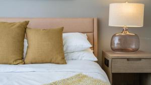 a bedroom with a bed with a lamp on a night stand at Landing Modern Apartment with Amazing Amenities (ID6647) in Sandy