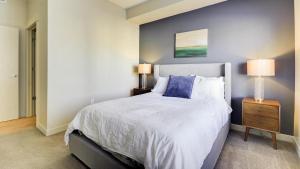 um quarto com uma cama grande e uma parede azul em Landing Modern Apartment with Amazing Amenities (ID6644) em Sandy