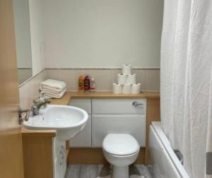 uma casa de banho com um WC branco e um lavatório. em Holiday Apartment In Old Town em Edinburgo