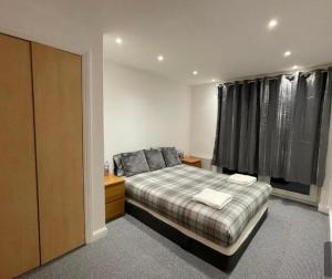 um quarto com uma cama e uma janela com cortinas em Holiday Apartment In Old Town em Edinburgo