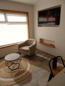 ein Wohnzimmer mit einem Sofa, einem Stuhl und einem Tisch in der Unterkunft M House Pichilemu in Pichilemu