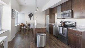 a kitchen with stainless steel appliances and a table at Landing Modern Apartment with Amazing Amenities (ID8910X05) in Omaha