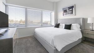 a bedroom with a bed and a desk with a television at Landing Modern Apartment with Amazing Amenities (ID8910X05) in Omaha