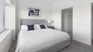 1 dormitorio blanco con 1 cama blanca grande con almohadas en Landing Modern Apartment with Amazing Amenities (ID8910X05) en Omaha
