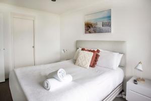a bedroom with a white bed with two towels on it at South Pacific Plaza - Official in Gold Coast