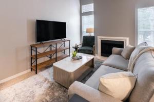 a living room with a couch and a flat screen tv at Landing Modern Apartment with Amazing Amenities (ID5301X35) in Irving