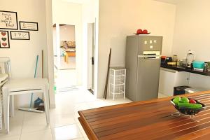 a kitchen with a stainless steel refrigerator and a table at Atalaia Vibes in Salinópolis