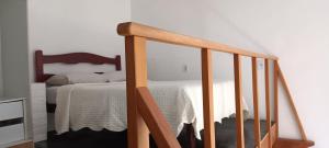 een slaapkamer met een bed en een houten wieg bij G.LO Loft AP 04 in Ponta Porã