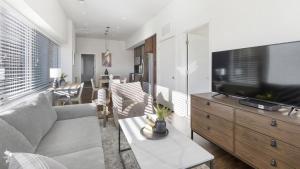 ein Wohnzimmer mit einem Sofa und einem Flachbild-TV in der Unterkunft Landing Modern Apartment with Amazing Amenities (ID9909X40) in Omaha