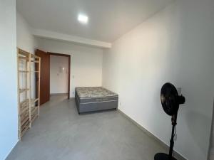 Habitación con cama y ventilador. en Temporada Praia Pinheira 2 Suítes 2 Garagens n2 en Palhoça