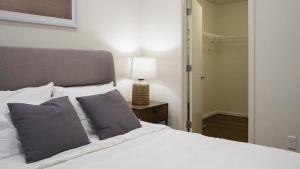 奥马哈Landing Modern Apartment with Amazing Amenities (ID8398X48)的卧室配有一张白色床和一张桌子上的台灯