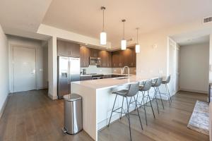 Landing Modern Apartment with Amazing Amenities (ID512) في دالاس: مطبخ مع منضدة وكراسي بار