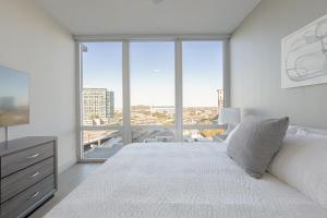 Landing Modern Apartment with Amazing Amenities (ID512) في دالاس: غرفة نوم بسرير ابيض كبير ونافذة كبيرة