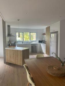 cocina con mesa de madera y suelo de madera en Tamara Beach House, en Inverloch