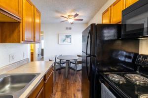 Il comprend une cuisine équipée d'un réfrigérateur noir et d'une table. dans l'établissement Landing Modern Apartment with Amazing Amenities (ID8426), à Tucson