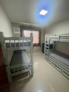 Cette chambre comprend 2 lits superposés et une fenêtre. dans l'établissement A Casa, à Maricá