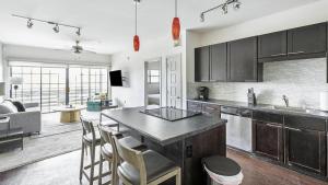 uma cozinha com mesa e cadeiras e uma sala de estar em Landing Modern Apartment with Amazing Amenities (ID1673) em Dallas