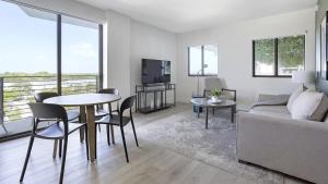 ein Wohnzimmer mit einem Tisch und einem Sofa in der Unterkunft Landing Modern Apartment with Amazing Amenities (ID7195) in Pompano Beach