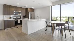 eine Küche mit einem Tisch, Stühlen und einer Theke in der Unterkunft Landing Modern Apartment with Amazing Amenities (ID7195) in Pompano Beach