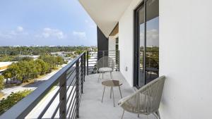 einen Balkon mit 2 Stühlen und einem Tisch in der Unterkunft Landing Modern Apartment with Amazing Amenities (ID7195) in Pompano Beach