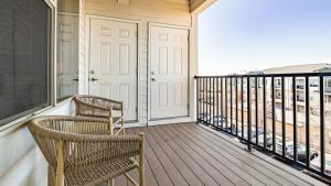 balkon z 2 krzesłami i białymi drzwiami w obiekcie Landing Modern Apartment with Amazing Amenities (ID7813X12) w Aurorze