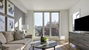 a living room with a couch and a tv at Landing Modern Apartment with Amazing Amenities (ID6509X60) in Tacoma