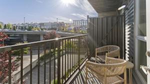 a balcony with two chairs and a view of a city at Landing Modern Apartment with Amazing Amenities (ID6509X60) in Tacoma