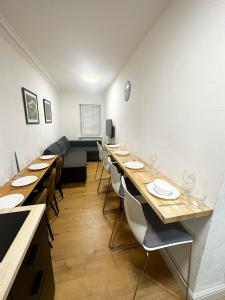 a dining room with long tables and chairs at Flat 1 Stay In Aldgate in London