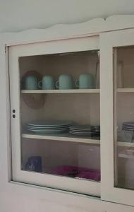 a cabinet with plates and cups and dishes in it at Paulora in Hidalgo del Parral