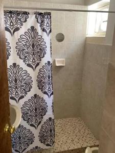 a shower with a black and white shower curtain at Paulora in Hidalgo del Parral