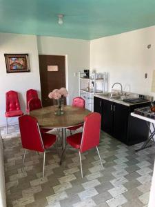 una cocina con mesa con sillas rojas y fregadero en Paulora, en Hidalgo del Parral