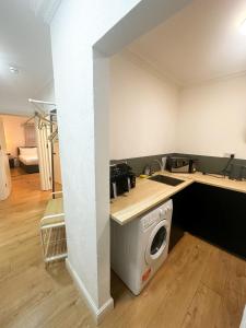 a kitchen with a washing machine in a room at Flat 1 Stay In Aldgate in London