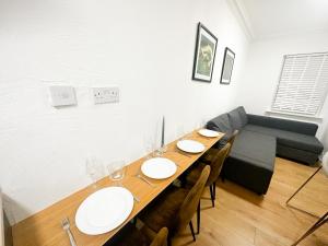 a dining room with a table and chairs and a couch at Flat 1 Stay In Aldgate in London