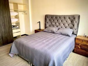 a bedroom with a large bed with a large headboard at Confort y comodidad in La Paz