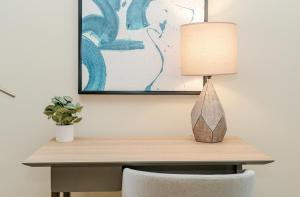 a desk with a lamp and a potted plant at Landing Modern Apartment with Amazing Amenities (ID2685X5) in Beachwood