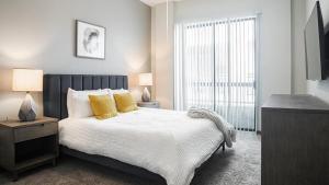 Un dormitorio con una cama con almohadas amarillas y una ventana en Landing Modern Apartment with Amazing Amenities (ID1988) en Houston