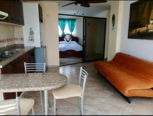 a kitchen with a couch and a bed in a room at EDIFICIO LOS DELFINES Walk to the Beach in Atacames