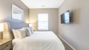 um quarto com uma cama e uma televisão na parede em Landing Modern Apartment with Amazing Amenities (ID7010X69) em Fort Wayne
