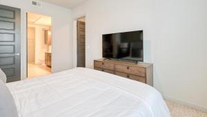 Landing Modern Apartment with Amazing Amenities (ID5143X81) في ذا وودلاندس: غرفة نوم بسرير وتلفزيون بشاشة مسطحة
