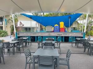 a cafeteria with tables and chairs and a stage at CHA Private Apts Diamond Beach in Gold Coast