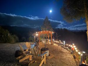 un grupo de sillas y un cenador por la noche en Sierra Mountain Lodge - Vacation Rentals - Yosemite, en Ahwahnee