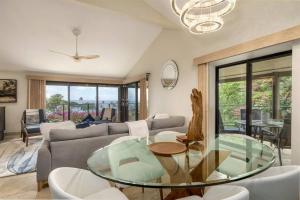 a living room with a couch and a glass table at Wailea Elua #202 — Huge Views — Luxury Remodel in Wailea