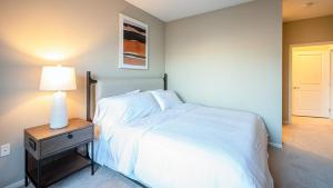 Landing Modern Apartment with Amazing Amenities (ID7380X13) في سانت بول: غرفة نوم مع سرير وطاولة مع مصباح