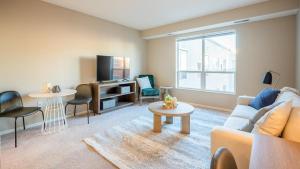 ein Wohnzimmer mit einem Sofa und einem TV in der Unterkunft Landing Modern Apartment with Amazing Amenities (ID7380X13) in Saint Paul