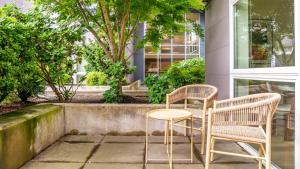dos sillas y una mesa frente a un edificio en Landing Modern Apartment with Amazing Amenities (ID9955X51) en Everett