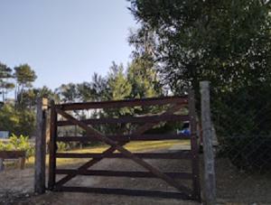 une porte en bois devant une clôture dans l'établissement Desconectate, à Balneario Argentino