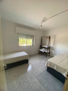 1 dormitorio con 2 camas, ventana y silla en Depto Latorre en General Pico